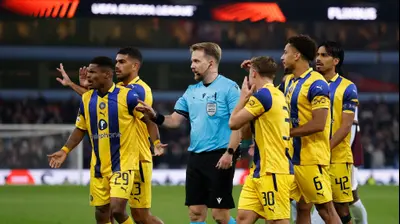 שחקני מכבי תל אביב מקיפים את השופט יוליאן ויינברגר. רויטרס