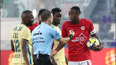 פרנן מאיימבו שחקן הפועל תל אביב עם השופט אוראל גרינפלד. דני מרון