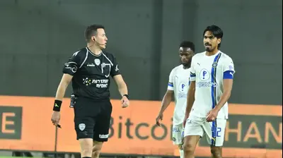 דור פרץ שחקן מכבי תל אביב עם השופט אביב קליין. ברני ארדוב