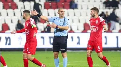 השופט אביאל לוי ליד שחקן בני סכנין, קרלו ברוצ'יץ'. קובי אליהו