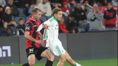 מנואל בנסון שחקן מכבי חיפה לפני דויד דומג'וני שחקן הפועל ירושלים. דני מרון