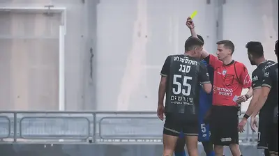 השופט דקל צינו שולף כרטיס צהוב לעבר נאור סבג שחקן הפועל חיפה. אריאל שלום