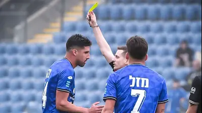 השופט דקל צינו שולף כרטיס צהוב לעבר יונתן כהן שחקן הפועל פתח תקוה. אריאל שלום