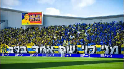 אוהדי מכבי תל אביב עם שלט לכבוד מני לוי. אריאל שלום