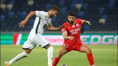 רועי זיקרי שחקן הפועל חיפה מול נאעל חוטבא שחקן מכבי בני ריינה. קובי אליהו