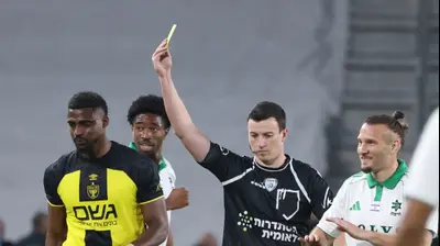 שון גולדברג שחקן מכבי חיפה לצד השופט אביב קליין. דני מרון