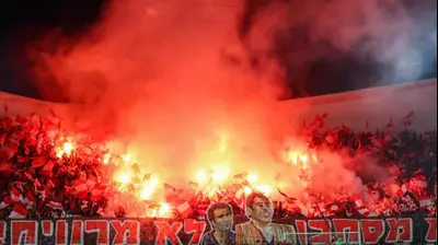 אוהדי הפועל תל אביב מדליקים אבוקות בדרבי. קובי אליהו