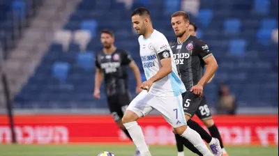 גיא חדידה שחקן עירוני טבריה לפני איבן קריצ'אק שחקן הפועל חיפה. מאור אלקסלסי