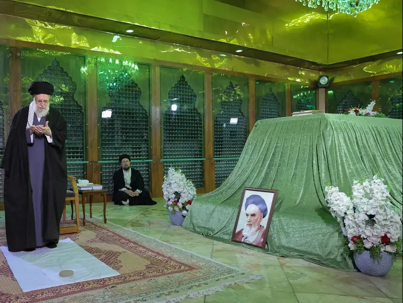 המנהיג העליון של איראן, עלי חמינאי, ונכדו של אייתוללה רוחאללה חומייני, חסן חומייני, מבקרים במקדש של מנהיג המהפכה האסלאמית של איראן בשנת 1979, בדרום טהרן.